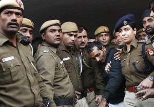 Policemen escort driver Shiv Kumar Yadav (in black jacket) who is accused of a rape outside a court in New Delhi December 8, 2014. U.S. online ride-hailing service Uber has been banned from operating in the Indian capital after a female passenger accused one of its drivers of rape, a case that has reignited a debate about the safety of women in the South Asian nation. REUTERS/Adnan Abidi (INDIA - Tags: CRIME LAW BUSINESS TRANSPORT)