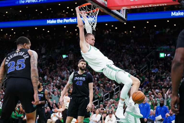 Jun 6, 2024; Boston, Massachusetts, USA; Boston Celtics center Kristaps Porzingis (8) dunks against Dallas Mavericks forward P.J. Washington (25) and forward Maxi Kleber (42) in the third quarter during game one of the 2024 NBA Finals at TD Garden. Mandatory Credit: David Butler II-USA TODAY Sports