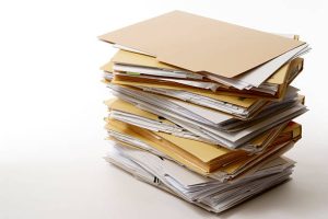 Stacked brown file folders isolated on white with soft shadow.