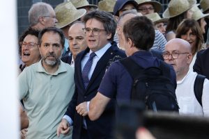 epa11535894 Former Catalan president Carles Puigdemont (C) makes his way to the stage before addressing supporters in Barcelona, Spain, 08 August 2024. Catalonia's former president Carles Puigdemont returned to Spain after seven years of self-imposed exile abroad, despite a pending arrest warrant. The Mossos d'Esquadra was deployed early morning on 08 August to secure access to the Parliament for the investiture of Salvador Illa. The plenary session of the Parliament will host the investiture debate of the Socialist leader Salvador Illa as the new president of the Generalitat, the government of Catalonia.  EPA/ALBERTO ESTEVEZ