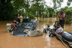 Flood-affected residents wait for a rescue boat to arrive in Taungoo, Myanmar's Bago region on September 14, 2024, following heavy rains in the aftermath of Typhoon Yagi. - Typhoon Yagi brought a colossal deluge of rain that has inundated a swathe of northern Vietnam, Laos, Thailand and Myanmar, triggering deadly landslides and widespread river flooding. (Photo by Sai Aung MAIN / AFP)