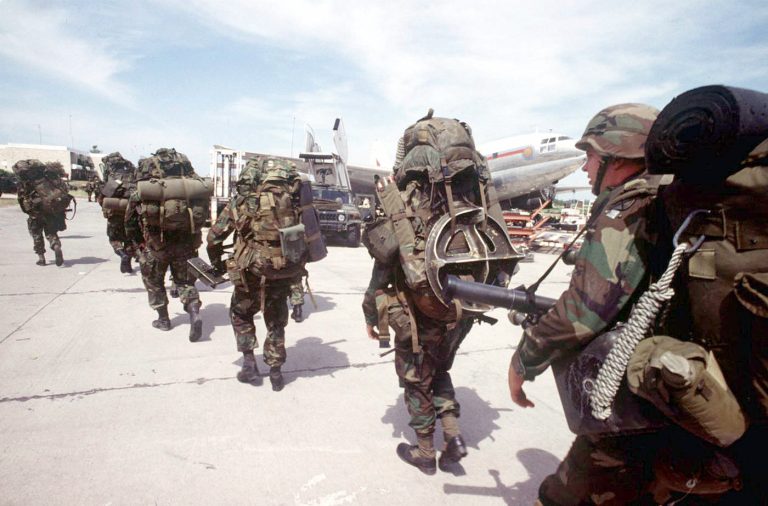 Soldiers of the 10th Mountain Division, Ft Drum, N.Y., dressed in full combat gear, line up to board UH-60 Blackhawk helicopters at Port-au-Prince airport Port-au-Prince, Haiti to take them to Bowlen 
Airfield during Restore Democracy on 22 Sept 94.