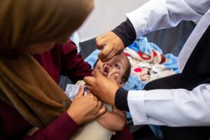 A nurse administers Polio vaccine drops to a young Palestinian patient at the Nasser hospital in Khan Yunis in the southern Gaza Strip on August 31, 2024, amid the ongoing conflict between Israel and the Hamas militant group. The World Health Organization said Israel had agreed to at least three days of "humanitarian pauses" in parts of Gaza, starting on August 31, to facilitate a vaccination drive after the territory recorded its first case of polio in a quarter of a century. (Photo by Jihad Al-Sharafi / AFP) (Photo by JIHAD AL-SHARAFI/AFP via Getty Images)