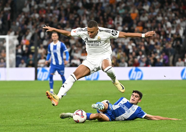 Real Madrid's French forward #09 Kylian Mbappe jumps for the ball during the Spanish league football match between Real Madrid CF and Deportivo Alaves at the Santiago Bernabeu stadium in Madrid on September 24, 2024. (Photo by JAVIER SORIANO / AFP)