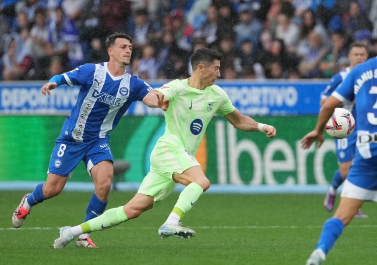 Barcelona's Polish forward #09 Robert Lewandowski fights for the ball with Alaves' Spanish defender #08 Antonio Blanco during the Spanish league football match between Deportivo Alaves and FC Barcelona at the Mendizorroza stadium in Vitoria on October 6, 2024. (Photo by Cesar Manso / AFP)